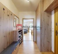 Interior of a 3-room apartment with a wooden hallway, a wardrobe, and a mirror on the wall.