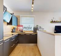 A kitchen in a 3-room apartment with a modern kitchen unit and a living area.