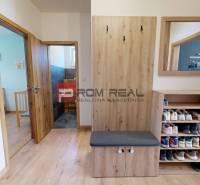 Entrance hall in a 3-room apartment with wooden accessories, a mirror, and a shoe cabinet.