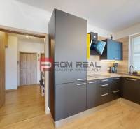 A kitchen in a 3-room apartment with wooden flooring and modern appliances.