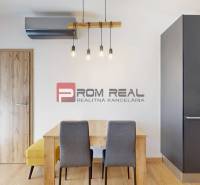 Dining table with chairs in a 3-room apartment, built-in kitchen unit with an oven.