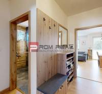 Hallway in a 3-room apartment with wooden details, entrance to the bathroom and living room.