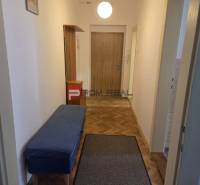 A hallway with a blue bench and wooden doors, furnishing a 2-room apartment.