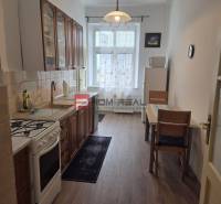 Kitchen in a 2-room apartment with a gas stove, dining table, and cabinets.