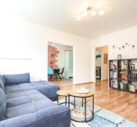 Living room in a three-room apartment with a sofa and a bookshelf.