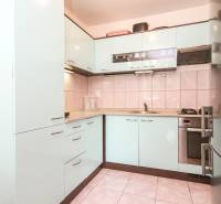 A kitchen with a corner unit in a 3-room apartment, light cabinets and built-in appliances.