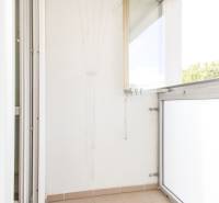 Glazed balcony in a 3-room apartment with tiles and a clothes dryer.