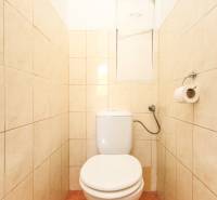 A toilet with light tiles in a 3-room apartment, simple and practical design.