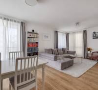 Living room with a sofa, dining table, and bookshelf in a 3-room apartment.