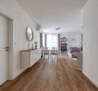 Interior of a 3-room apartment with wooden flooring, a dining table, and a living room.