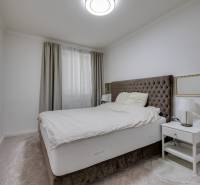 Bedroom in a 3-room apartment with a comfortable bed, a nightstand, and curtains.