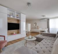 Living room in a 3-room apartment with a comfortable sofa, TV wall, and dining table.