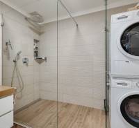 Bathroom with shower and washing machine in a 3-room apartment.