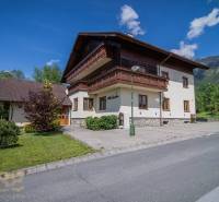 A recreational apartment in the High Tatras, surrounded by greenery, blue sky, mountains in the background.