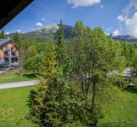 View from a holiday apartment in the High Tatras, with mountains and green trees.