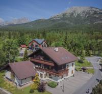 Recreational apartments in the High Tatras, surrounded by dense forest and majestic mountains.
