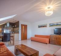 Living room of a holiday apartment with sofas, a dining table, and a television.