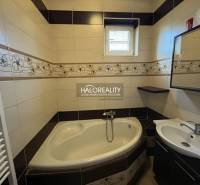 A bathroom with a corner bathtub and a sink in a renovated 3-room apartment.