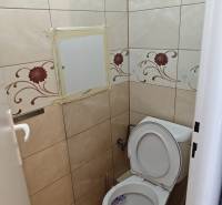 A bathroom with tiles and a floral pattern in a 2-room apartment.