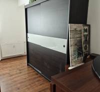 Sliding door wardrobe with decorations, wooden floor in a 2-room apartment.