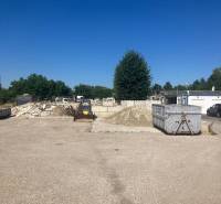 Commercial land on Popradská Street in Bratislava, Podunajské Biskupice, with containers and construction site.