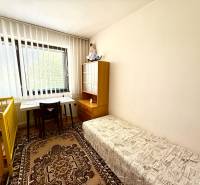 Children's room in a family house with a desk, bed, and carpet.