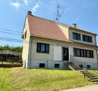 A family house in Koválov with a red and white roof and a manicured lawn.
