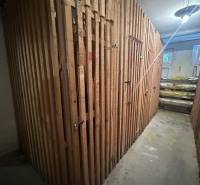 A wooden shed in the basement, secured with locks.