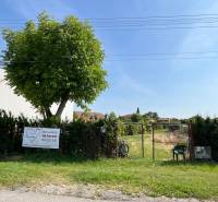 Plots - housing in the village of Dolný Bar, fenced plot with a tree and a gate.