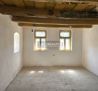 A room with a wooden ceiling and two windows in a family house.