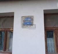 Two neglected windows of a family house in Ladzany with an erosive inscription on the wall.