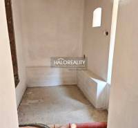 An untidy room in a family house with visible construction elements and a beamed ceiling.