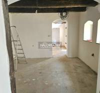 An unfinished interior in a family house with exposed wooden beams and a ladder.
