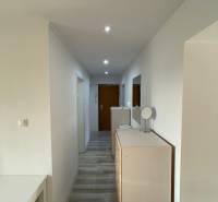 Hallway of a 2-room apartment with white walls and built-in lighting.