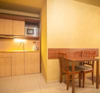 Kitchen corner with a sink, microwave, and dining table in a holiday apartment.