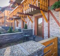 A recreational apartment in Veľká Lomnica with a stone terrace and wooden balconies.