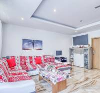 Living room in a 2-room apartment with a colorful sofa and TV, bright interior.