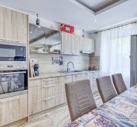 A kitchen in a 2-room apartment with wooden cabinets and built-in appliances.