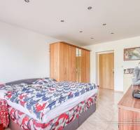 A bedroom in a two-room apartment with a bed, a wardrobe, and decorations on the dresser.