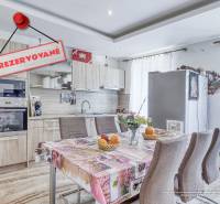 A kitchen in a 2-room apartment with a table, appliances, and a 