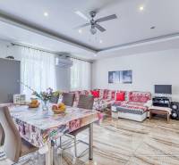 A spacious living room with a dining table in a 2-room apartment, light walls and a patterned sofa.
