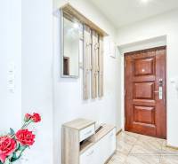 Entrance hall in a 2-room apartment with wooden doors and a mirror, decorated with red flowers.
