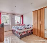 Bedroom in a two-room apartment with a bed, wardrobe, and a TV on the wall.