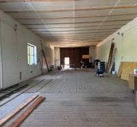 Interiors of warehouses and halls with wooden floors, ladders, and wooden boards on the wall.