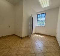 An empty room with a light floor and a large window in a warehouse and hall.