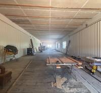 Spacious interior of warehouses and halls with wooden flooring, building materials, and tools.