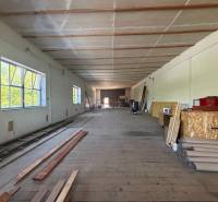 Interior of warehouses and halls with wooden flooring, shelves, and building materials.