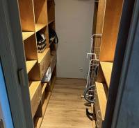 Wardrobe in a 2-room apartment, wooden shelves, practical storage spaces.
