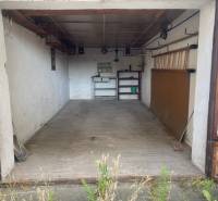 An empty garage in Zvolen with shelves and tools on the wall.
