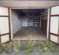 An open garage with an old interior and plants in front of the garage in Zvolen.